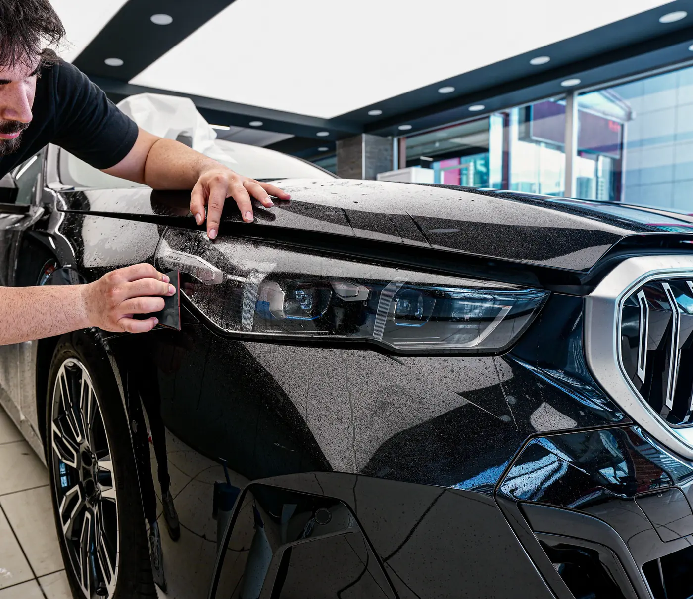Capla uygulama alanında siyah BMW 520 far çevresine şeffaf PPF uygulanırken